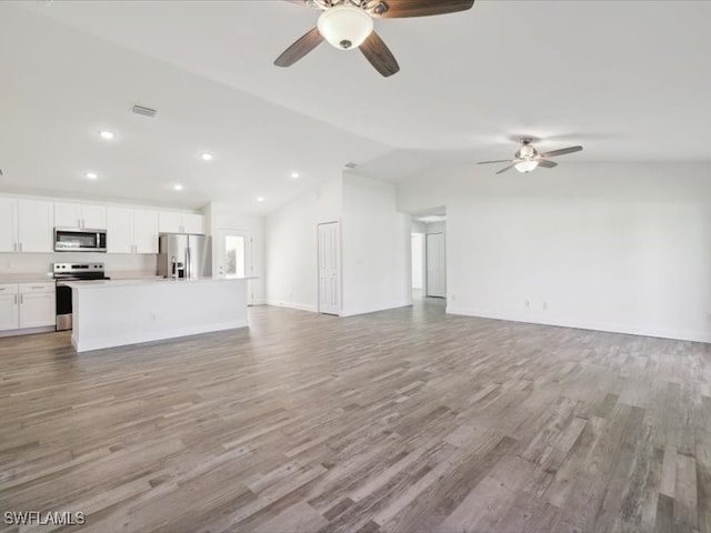 unfurnished living room with ceiling fan, light hardwood / wood-style flooring, and vaulted ceiling