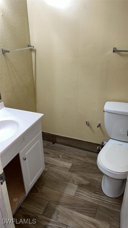 bathroom featuring vanity, hardwood / wood-style flooring, and toilet