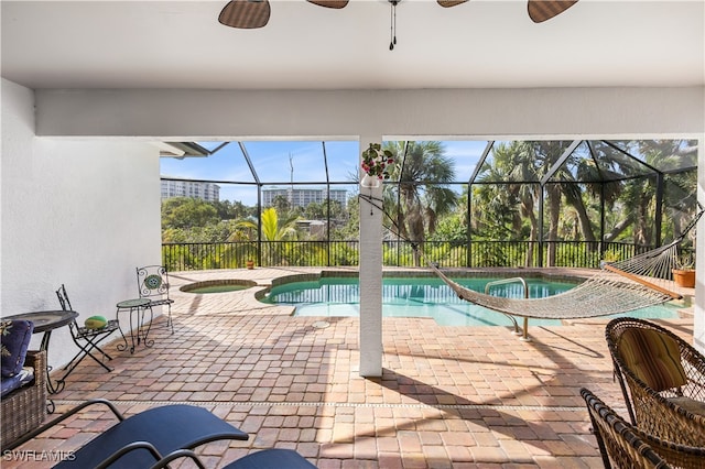 view of swimming pool featuring a lanai, a patio area, and an in ground hot tub