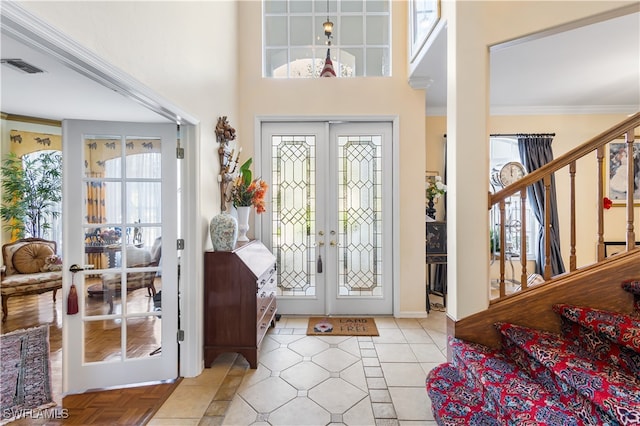 tiled entrance foyer with french doors and ornamental molding