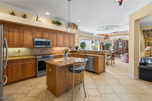 kitchen featuring appliances with stainless steel finishes, crown molding, sink, a center island, and a breakfast bar area