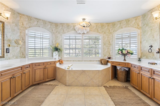 bathroom with vanity, a wealth of natural light, tile patterned flooring, and a relaxing tiled tub