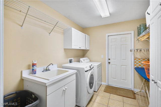 laundry area with light tile patterned flooring, sink, cabinets, and washing machine and clothes dryer