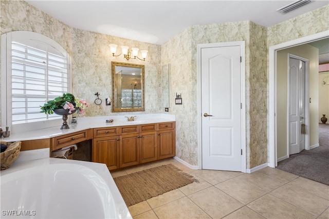 bathroom with tile patterned floors, vanity, a bath, and an inviting chandelier