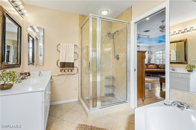 bathroom featuring tile patterned floors, ceiling fan, a shower with door, and vanity