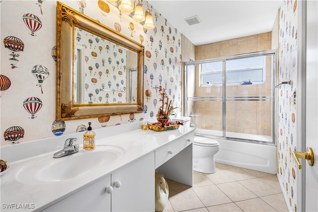 full bathroom featuring tile patterned flooring, vanity, toilet, and bath / shower combo with glass door