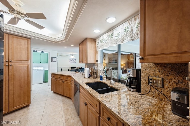 kitchen featuring light stone countertops, sink, washer / clothes dryer, decorative backsplash, and ornamental molding