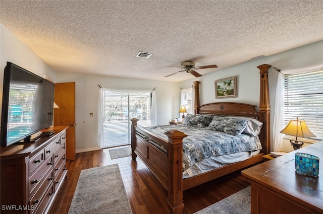 bedroom with ceiling fan, dark hardwood / wood-style flooring, a textured ceiling, and access to outside