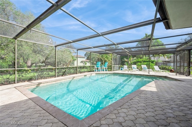 view of swimming pool with a patio area and glass enclosure