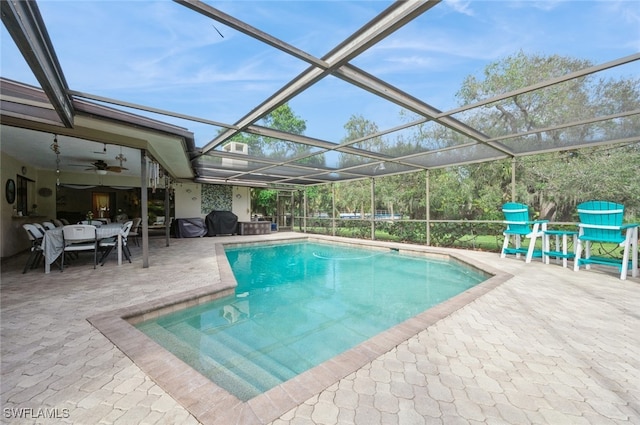 view of pool featuring ceiling fan, a lanai, a patio area, and a grill