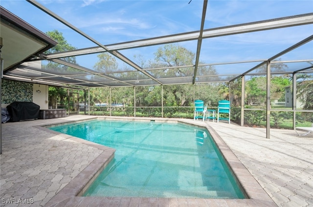 view of swimming pool featuring a lanai, a patio area, and grilling area