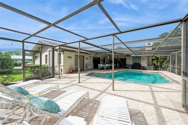 view of pool with a patio and glass enclosure