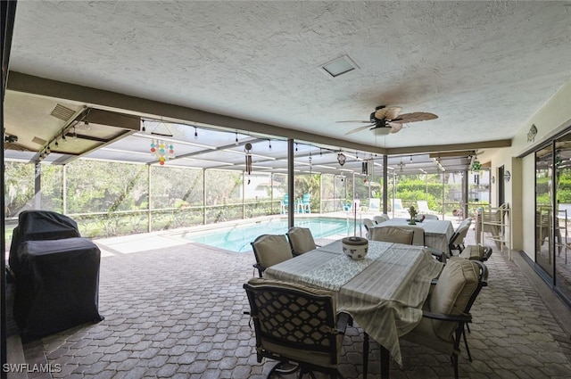 view of patio with glass enclosure and ceiling fan