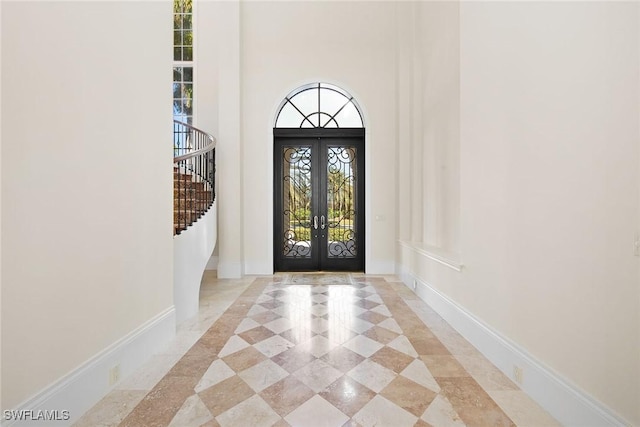 28790 Blaisdell Dr, Naples, FL 34119 - entrance foyer featuring french doors, a towering ceiling, inlaid floor details, stairs, and baseboards