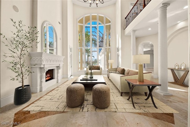 28790 Blaisdell Dr, Naples, FL 34119 - living area featuring a towering ceiling, a lit fireplace, baseboards, a chandelier, and recessed lighting