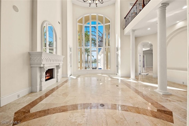 28790 Blaisdell Dr, Naples, FL 34119 - entryway featuring inlaid floor details, marble tiled floors, a high ceiling, a fireplace, and baseboards
