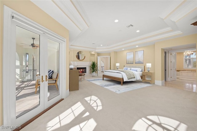 28790 Blaisdell Dr, Naples, FL 34119 - bedroom with light carpet, ornamental molding, french doors, a tray ceiling, and a lit fireplace