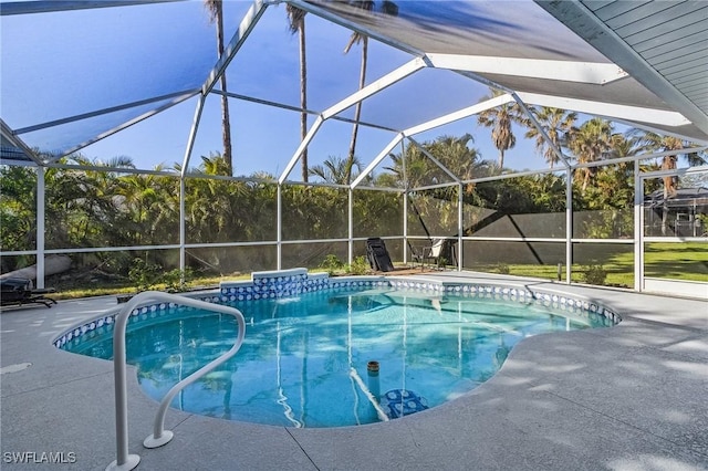 view of pool featuring glass enclosure and a patio area