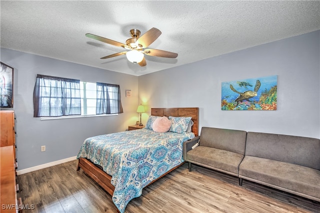 bedroom with ceiling fan, a textured ceiling, and hardwood / wood-style flooring