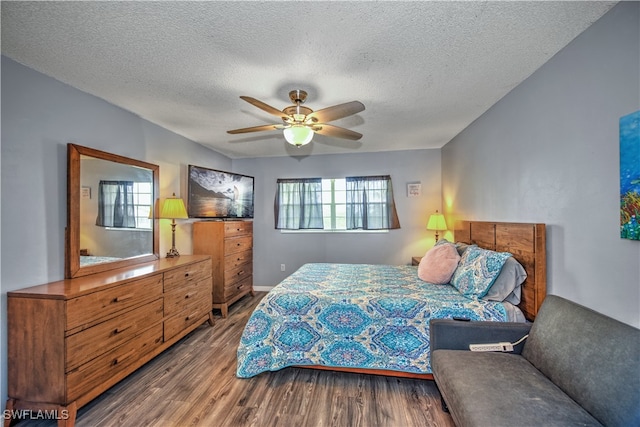 bedroom with ceiling fan, wood-type flooring, and a textured ceiling