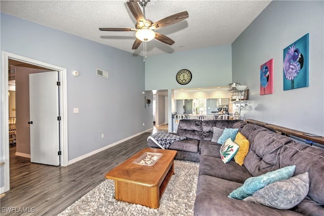 living room with ceiling fan, a textured ceiling, and hardwood / wood-style flooring