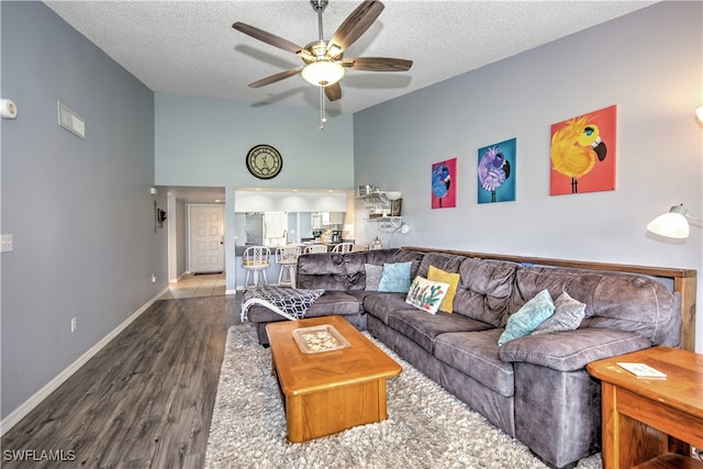 living room featuring ceiling fan, wood-type flooring, and a textured ceiling