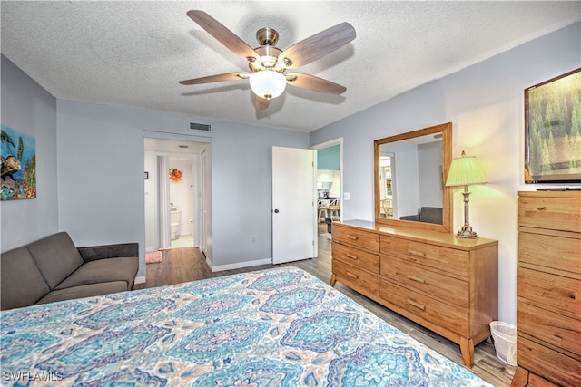 bedroom featuring wood-type flooring, a textured ceiling, and ceiling fan