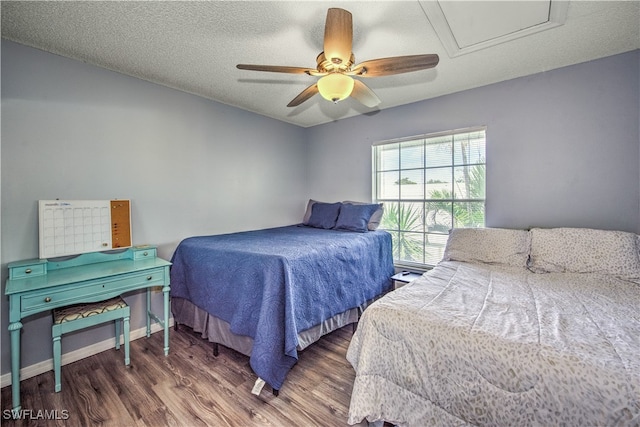 bedroom with ceiling fan, dark hardwood / wood-style flooring, and a textured ceiling