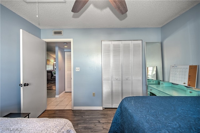 bedroom featuring hardwood / wood-style flooring, ceiling fan, a textured ceiling, and a closet