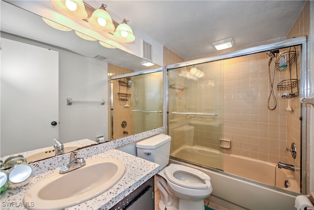 full bathroom with vanity, toilet, and shower / bath combination with glass door