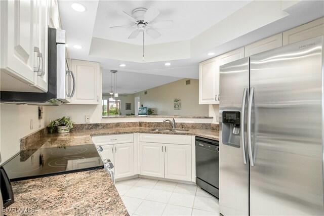 kitchen featuring a raised ceiling, sink, black appliances, light tile patterned floors, and white cabinetry