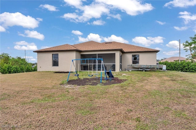 back of house with a playground, a sunroom, and a yard