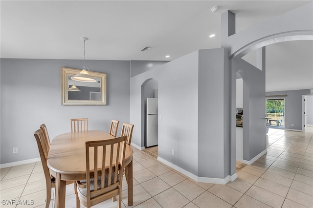 dining room featuring light tile patterned floors and lofted ceiling