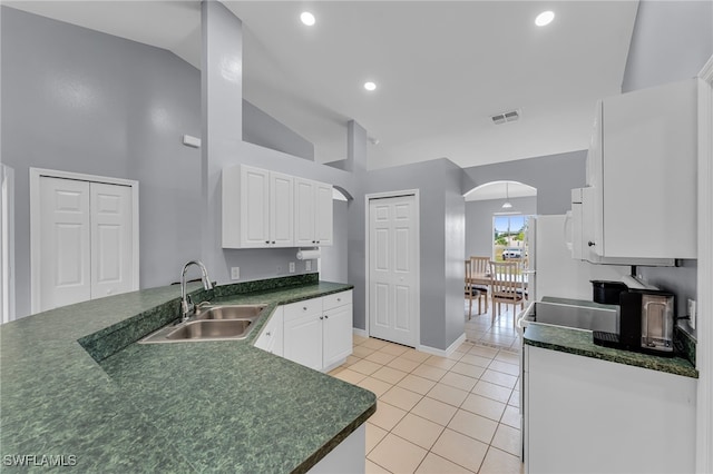 kitchen with high vaulted ceiling, white cabinets, sink, light tile patterned flooring, and kitchen peninsula