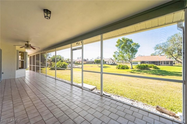 unfurnished sunroom with ceiling fan