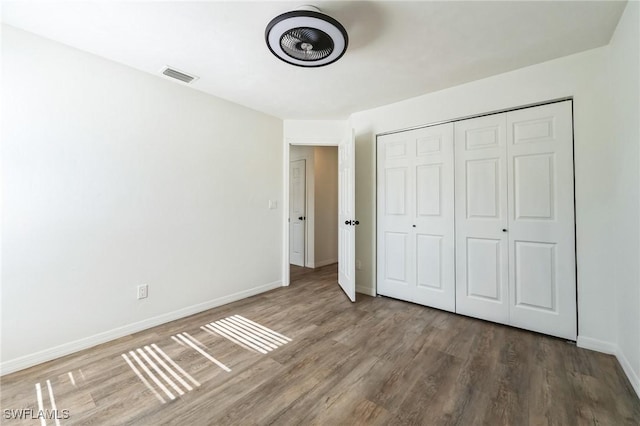 unfurnished bedroom with a closet and dark wood-type flooring