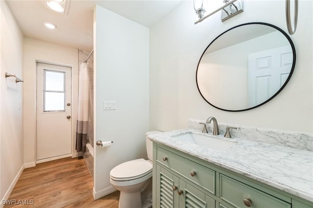 bathroom featuring walk in shower, vanity, wood-type flooring, and toilet