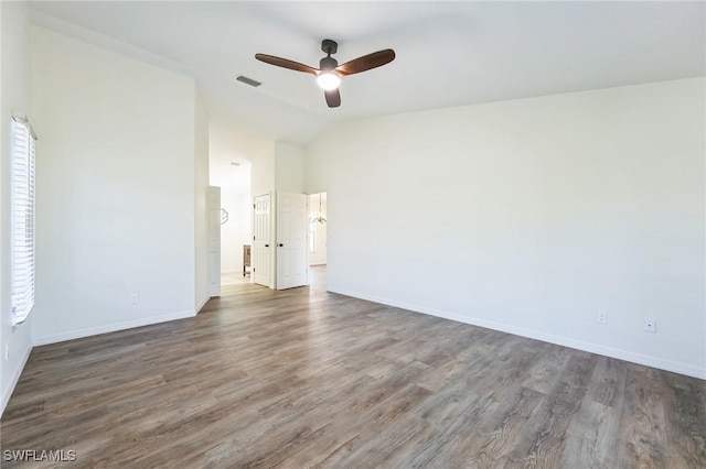 empty room with vaulted ceiling, ceiling fan, and dark wood-type flooring