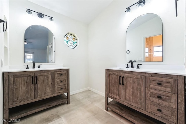 bathroom featuring ceiling fan, plenty of natural light, vanity, and vaulted ceiling