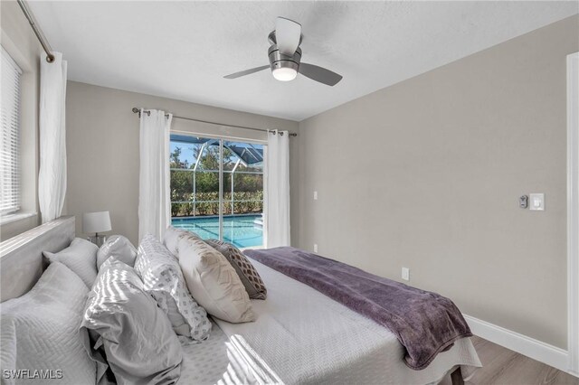 bedroom featuring access to outside, hardwood / wood-style flooring, and ceiling fan