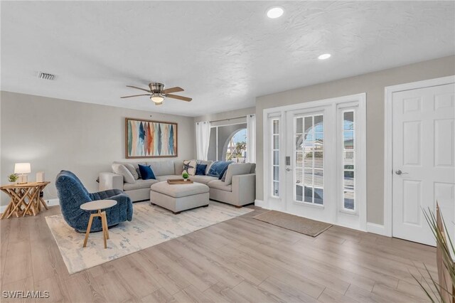 living room featuring ceiling fan and light hardwood / wood-style flooring