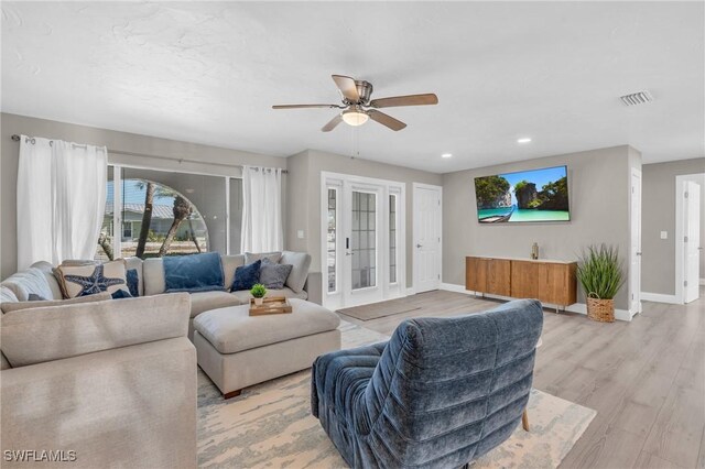 living room with light wood-type flooring and ceiling fan