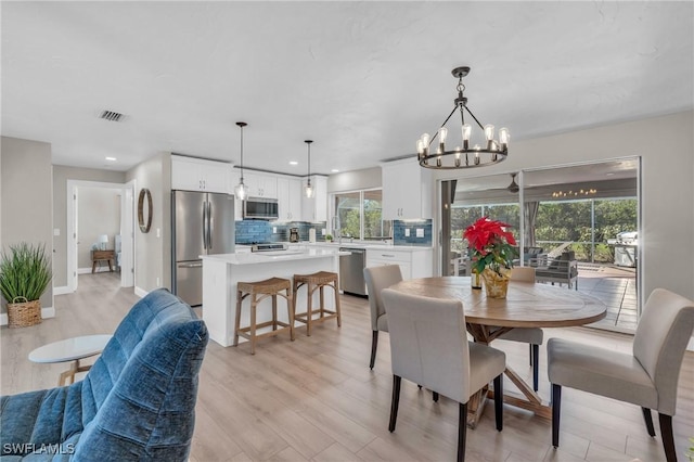 dining area featuring recessed lighting, visible vents, baseboards, light wood-style floors, and an inviting chandelier