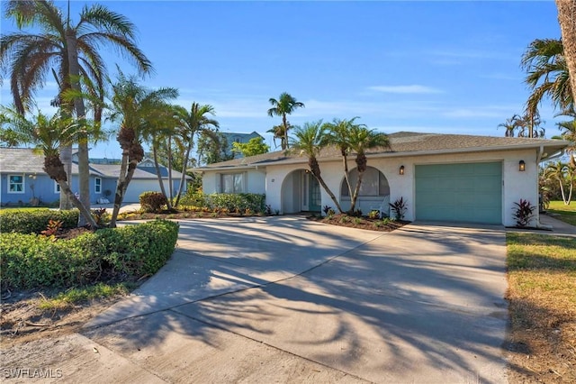 single story home with a garage, driveway, and stucco siding