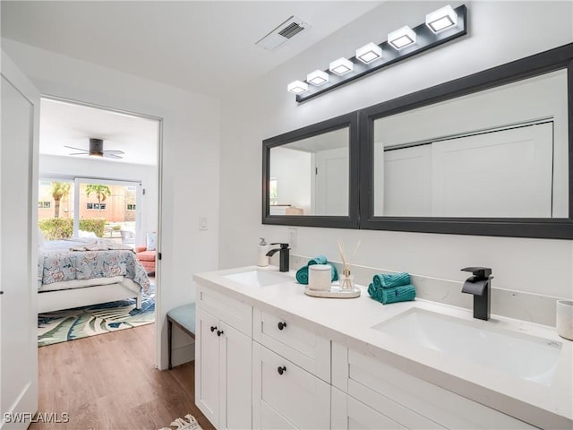 bathroom with hardwood / wood-style flooring, ceiling fan, and vanity