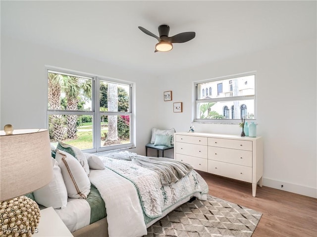 bedroom featuring light hardwood / wood-style floors, multiple windows, and ceiling fan