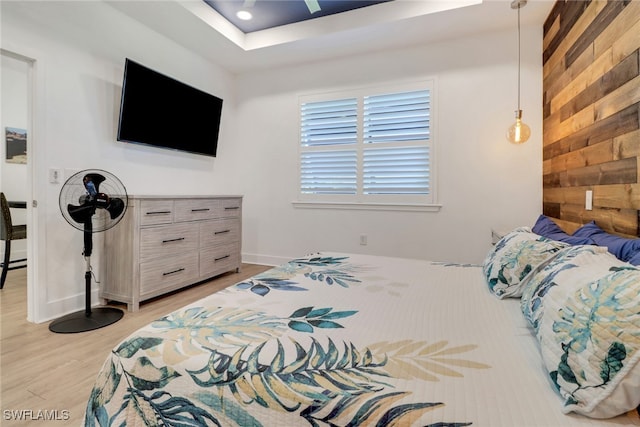 bedroom with wood walls and light wood-type flooring