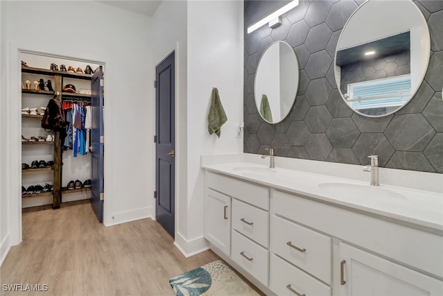 bathroom featuring hardwood / wood-style flooring, decorative backsplash, and vanity