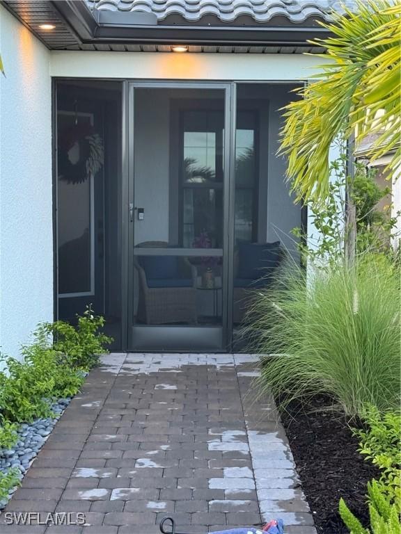 20564 Pebble Glen Dr, Estero, FL 33928 - doorway to property with stucco siding and a tile roof