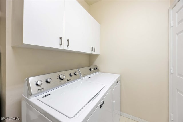 laundry room featuring washer and dryer and cabinets